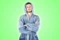 Portrait of young caucasian bearded man in blue bathrobe with crossed hands isolated on green background Royalty Free Stock Photo