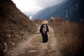 Rear view of a Young boy dressed as Samurai with the painted dragon on Kimono walking by the mountain trail in the cloudy weather Royalty Free Stock Photo