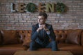 Portrait of young caucasian business man in formal suit sitting on brown sofa Royalty Free Stock Photo