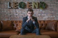 Portrait of young caucasian business man in formal suit sitting on brown sofa Royalty Free Stock Photo