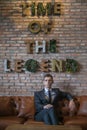 Portrait of young caucasian business man in formal suit sitting on brown sofa Royalty Free Stock Photo