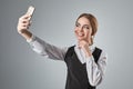 Portrait of young caucasian business woman in suit doing selfie on the phone. Royalty Free Stock Photo