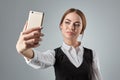 Portrait of young caucasian business woman in suit doing selfie on the phone. Royalty Free Stock Photo