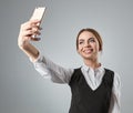 Portrait of young caucasian business woman in suit doing selfie on the phone. Royalty Free Stock Photo