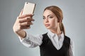 Portrait of young caucasian business woman in suit doing selfie on the phone. Royalty Free Stock Photo