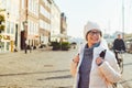 Portrait of a young Caucasian European woman tourist in glasses for the view of a white hat and a down jacket with a black Royalty Free Stock Photo