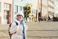 Portrait of a young Caucasian European woman tourist in glasses for the view of a white hat and a down jacket with a black Royalty Free Stock Photo