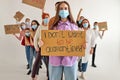 portrait of young caucasian female in protective face mask with cardboard in hands