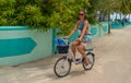 PORTRAIT: Young Caucasian female tourist rides a bike as she goes snorkeling. Royalty Free Stock Photo