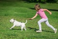 Girl chasing a dog in a park Royalty Free Stock Photo