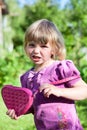 Portrait of young Caucasian girl stressing with small pink bag in her hands, wearing dress in summer garden Royalty Free Stock Photo