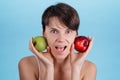 Portrait of young Caucasian girl who holds a red and green Apple in her hands as a concept of choosing the right food Royalty Free Stock Photo