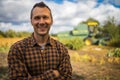 Portrait of young Caucasian handsome happy man farmer standing in field and smiling to camera.