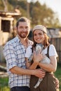 Portrait of young Caucasian happy farmer couple holding a little goat in their arms. Family business at ecological farm Royalty Free Stock Photo