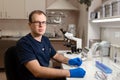 Portrait of young caucasian male scientist, medical worker, tech or graduate student works in modern biological laboratory Royalty Free Stock Photo