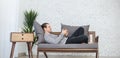 Portrait of young caucasian man sleep relax on sofa with smartphone. Royalty Free Stock Photo