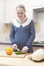 Portrait of Young Caucasian Pregnant Woman Making Salad with Vegetables on Kitchen Royalty Free Stock Photo