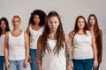 Portrait of young caucasian tattooed woman with dreadlocks in white shirt looking at camera. Group of diverse women Royalty Free Stock Photo