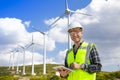 Young worker looking and checking wind turbines at field Royalty Free Stock Photo