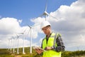Young worker looking and checking wind turbines at field Royalty Free Stock Photo