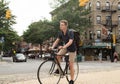 Portrait of young caucasian teenager riding bike on city street