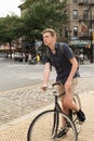 Portrait of young caucasian teenager riding bike on city street