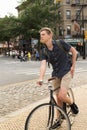 Portrait of young caucasian teenager riding bike on city street