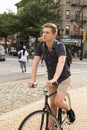 Portrait of young caucasian teenager riding bike on city street