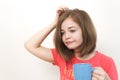 Portrait of young caucasian woman girl, yawning, tired or sleepy with bushy disheveled hair holding a mug of coffee Royalty Free Stock Photo