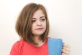 Portrait of young caucasian woman girl, yawning, tired or sleepy with bushy disheveled hair holding a mug of coffee