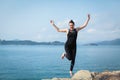 Portrait of young caucasian woman jumping with joy and euphoria at the beach Royalty Free Stock Photo