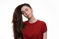 Portrait of a young caucasian woman with a ponytail hanging over her head. White background. The concept of unruly hair and its