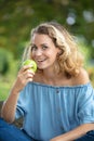 portrait young charming blonde woman biting green apple Royalty Free Stock Photo