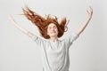 Portrait of young cheerful beautiful redhead girl smiling with closed eyes shaking hair over white background. Royalty Free Stock Photo