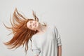 Portrait of young cheerful beautiful redhead girl smiling with closed eyes shaking head and hair over white background. Royalty Free Stock Photo