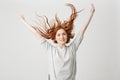 Portrait of young cheerful beautiful redhead girl smiling looking at camera shaking hair over white background. Royalty Free Stock Photo