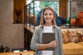 Portrait of a young cheerful caucasian woman, female office worker holding digital tablet and looking at camera while