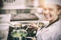 Portrait of young cheerful chef stirring sauce