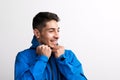 Portrait of a young hispanic man with blue anorak in a studio.