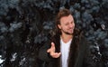 Portrait of a young cheerful man in a jacket on the background of Christmas tree branches Royalty Free Stock Photo