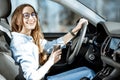 Woman with coffee driving a car