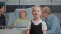 Portrait of young child standing in hospital ward at clinic