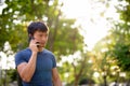 Portrait of young Asian man talking on the phone at the park outdoors Royalty Free Stock Photo
