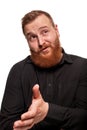 Portrait of a young, chubby, redheaded man in a black shirt making faces at the camera, isolated on a white background Royalty Free Stock Photo