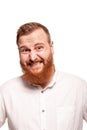 Portrait of a young, chubby, redheaded man in a white shirt making faces at the camera, isolated on a white background Royalty Free Stock Photo