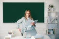 Portrait of young clever smart female college student studying in classroom on class with blackboard background. Royalty Free Stock Photo