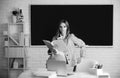 Portrait of young clever smart female college student studying in classroom on class with blackboard background. Royalty Free Stock Photo