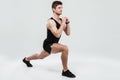 Portrait of a young concentrated man doing squats exercise Royalty Free Stock Photo