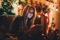 Portrait of a young concentrated woman reading comething before christmas