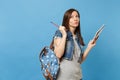 Portrait of young concerned woman student in denim clothes with backpack taking exam thinking about test hold notebook